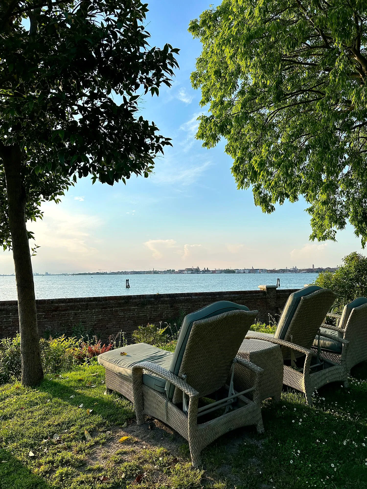 Wicker loungers in the garden of the San Clemente Palace Kempinski, facing the Venice lagoon.